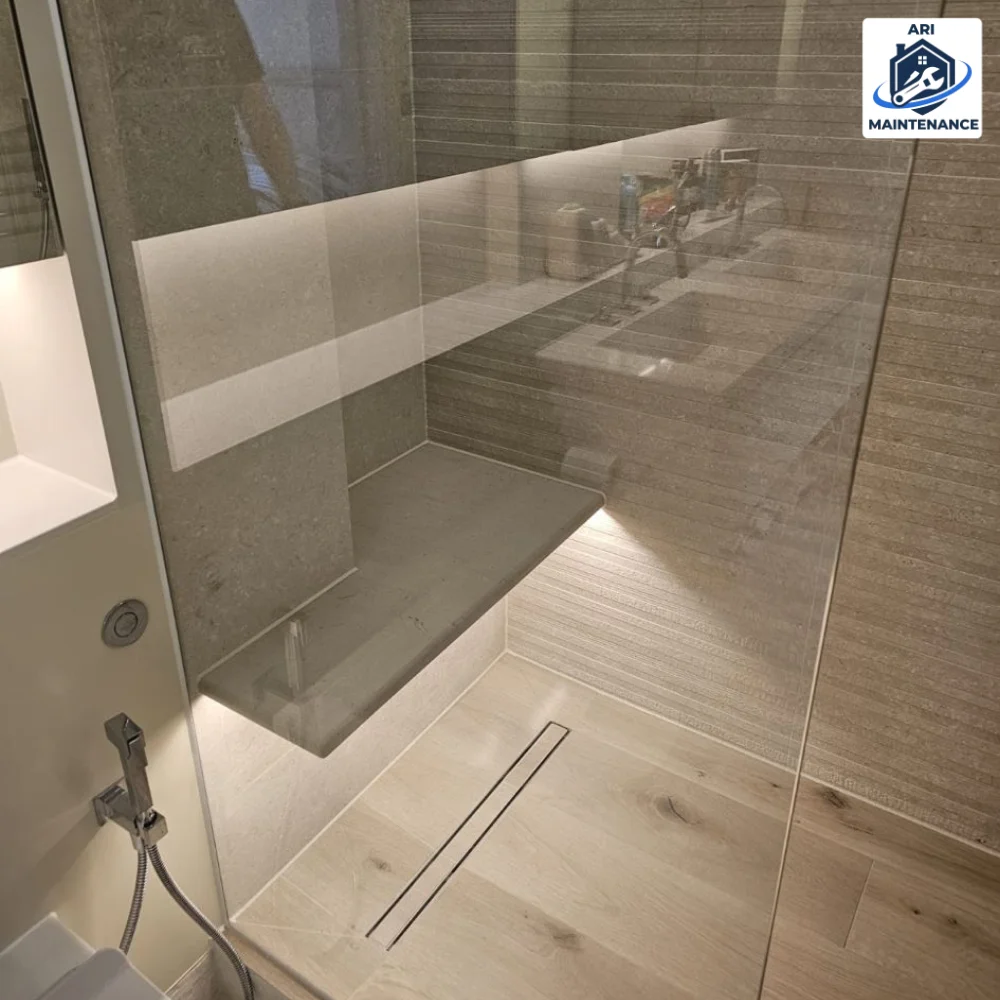 Walk-in shower with built-in stone bench seat.