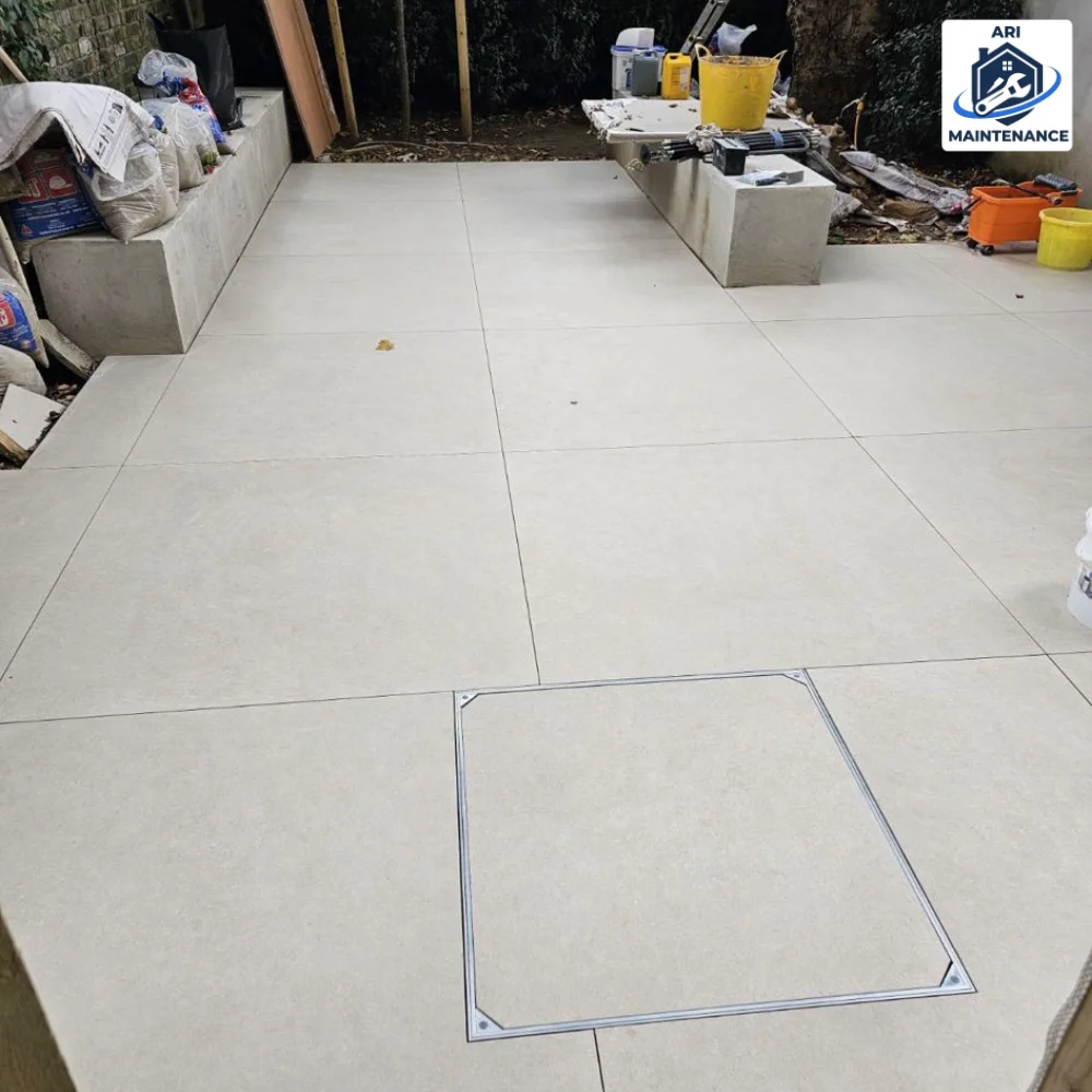 BEFORE — patio area with sandbags, bricks and material piles, mid-install.