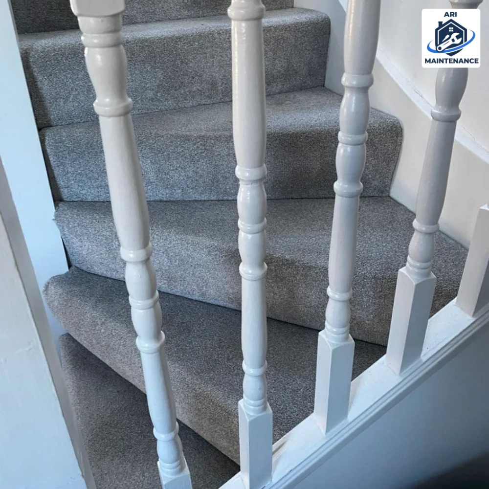 New grey carpet runner on stairs with freshly painted white turned spindles.