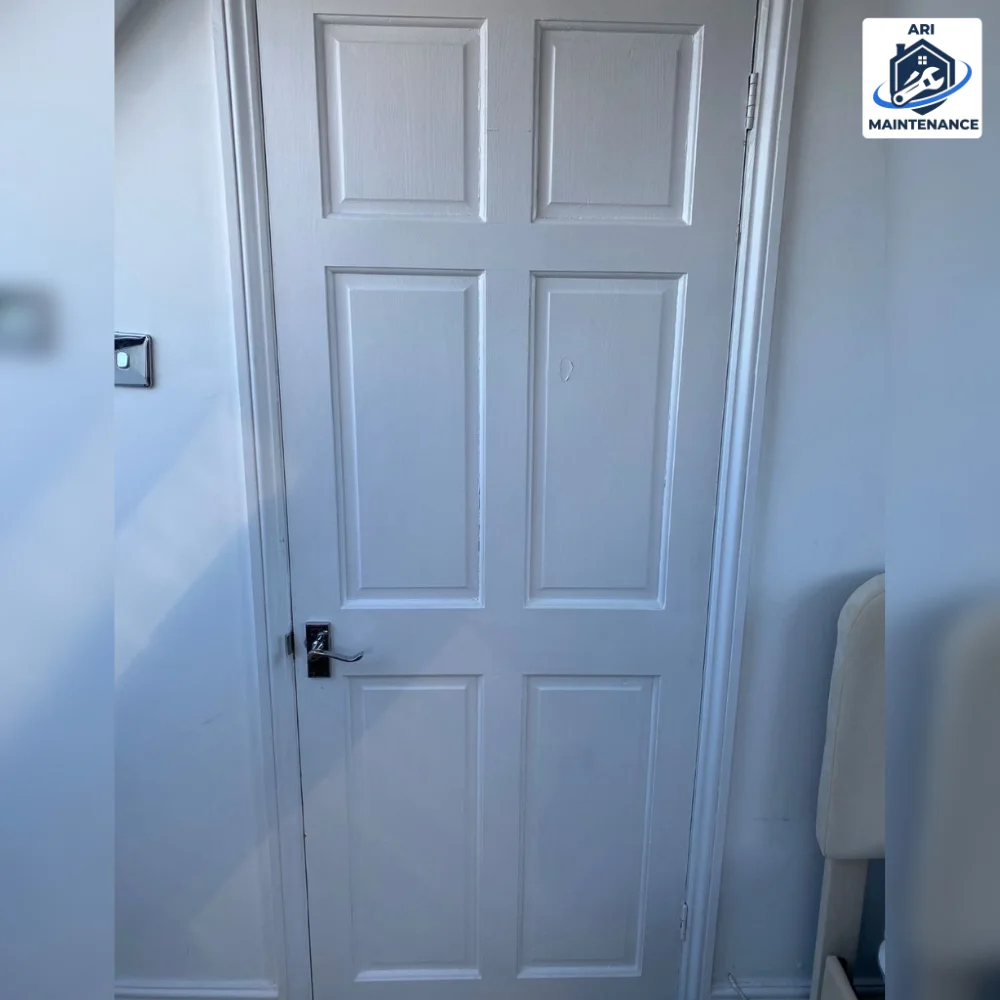 Newly painted white six-panel door, closed.