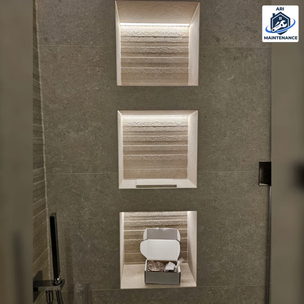 Three lit recessed shower niches in vertical layout.