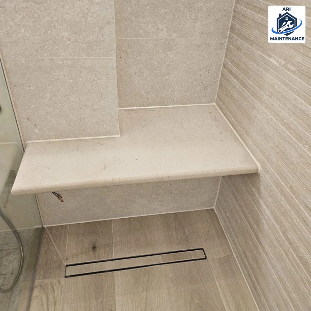 Stone bench and chrome linear drain detail.