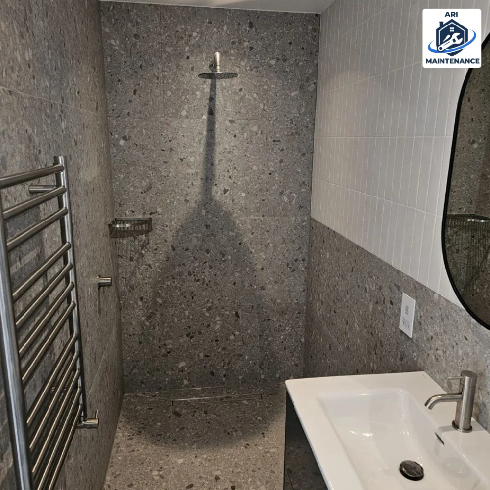 Walk-in terrazzo shower with chrome thermostat — front view.