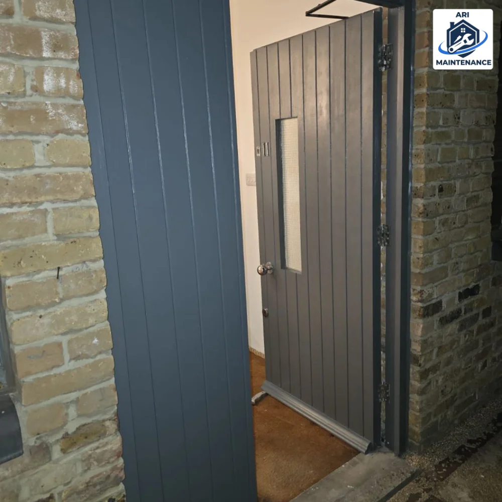 Steel security door against exposed brick wall.