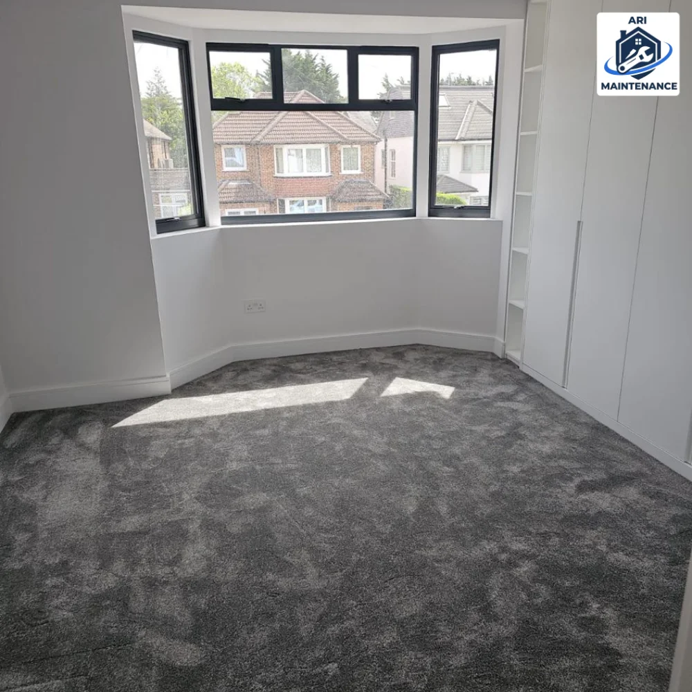 Refurbished bedroom with new grey carpet, white walls and bay window.