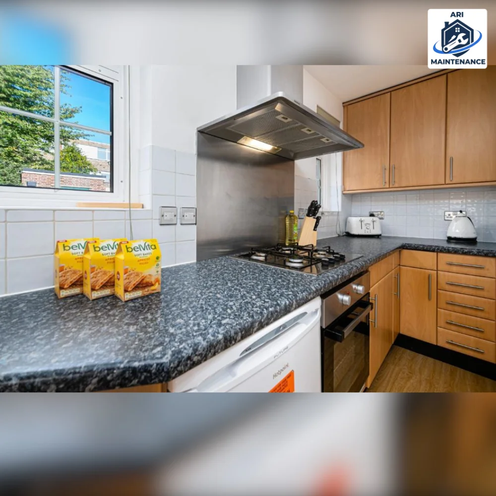 Refurbished kitchen with wooden cupboards, granite worktop and stainless extractor.