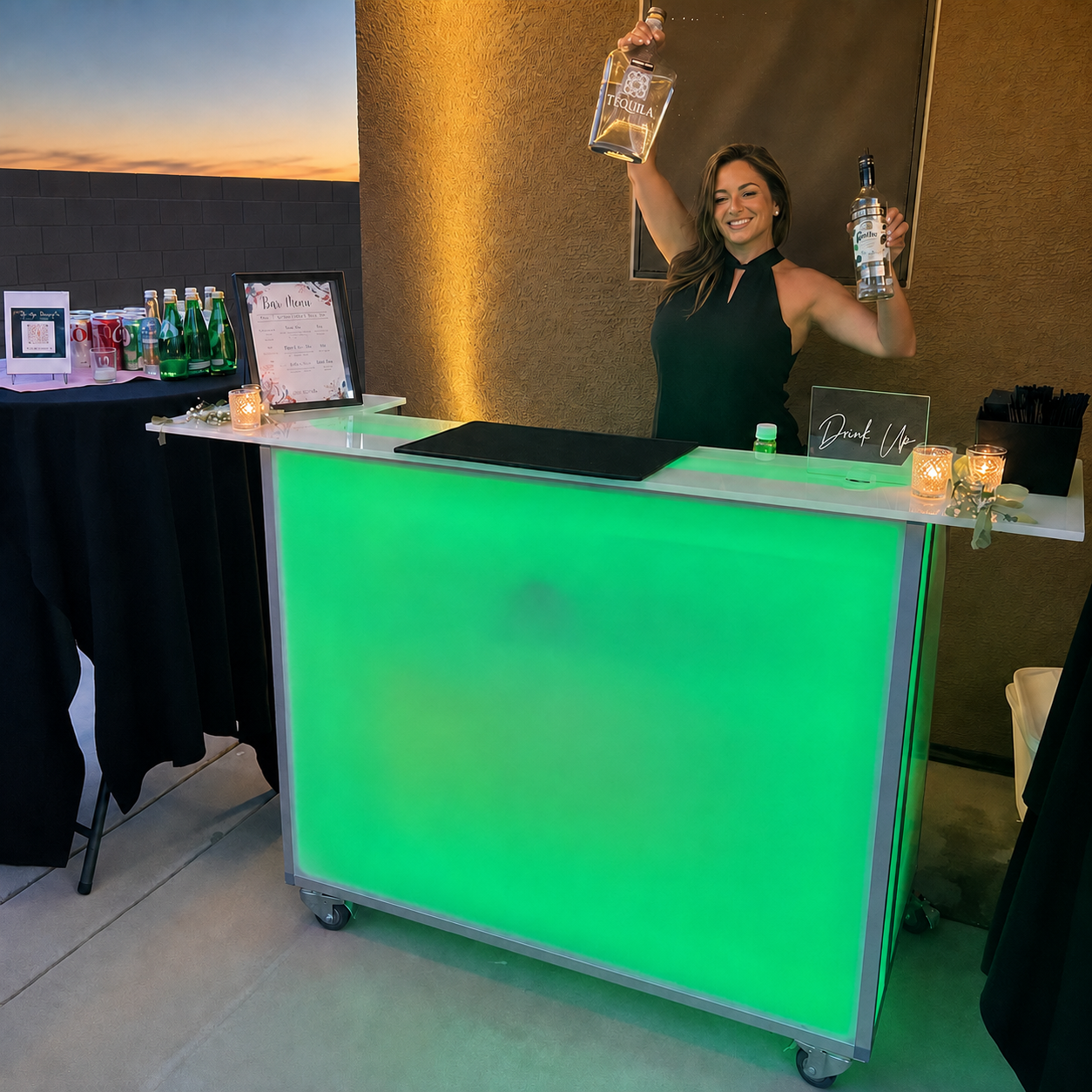 Gilded Glass bartender behind a green illuminated mobile bar