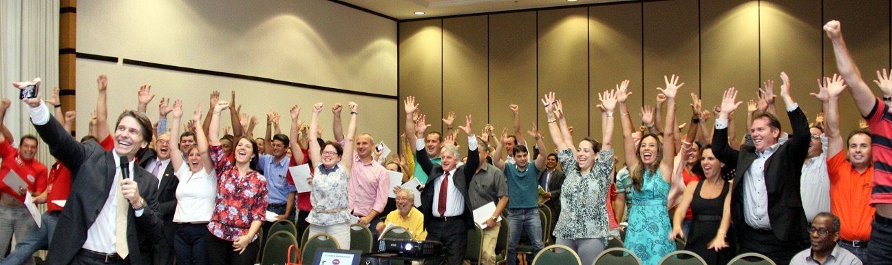 Grupo de participantes de workshop com os braços erguidos no fim da sessão