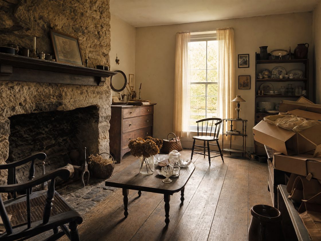 A farmhouse parlor with furniture and belongings still in place before an estate sale