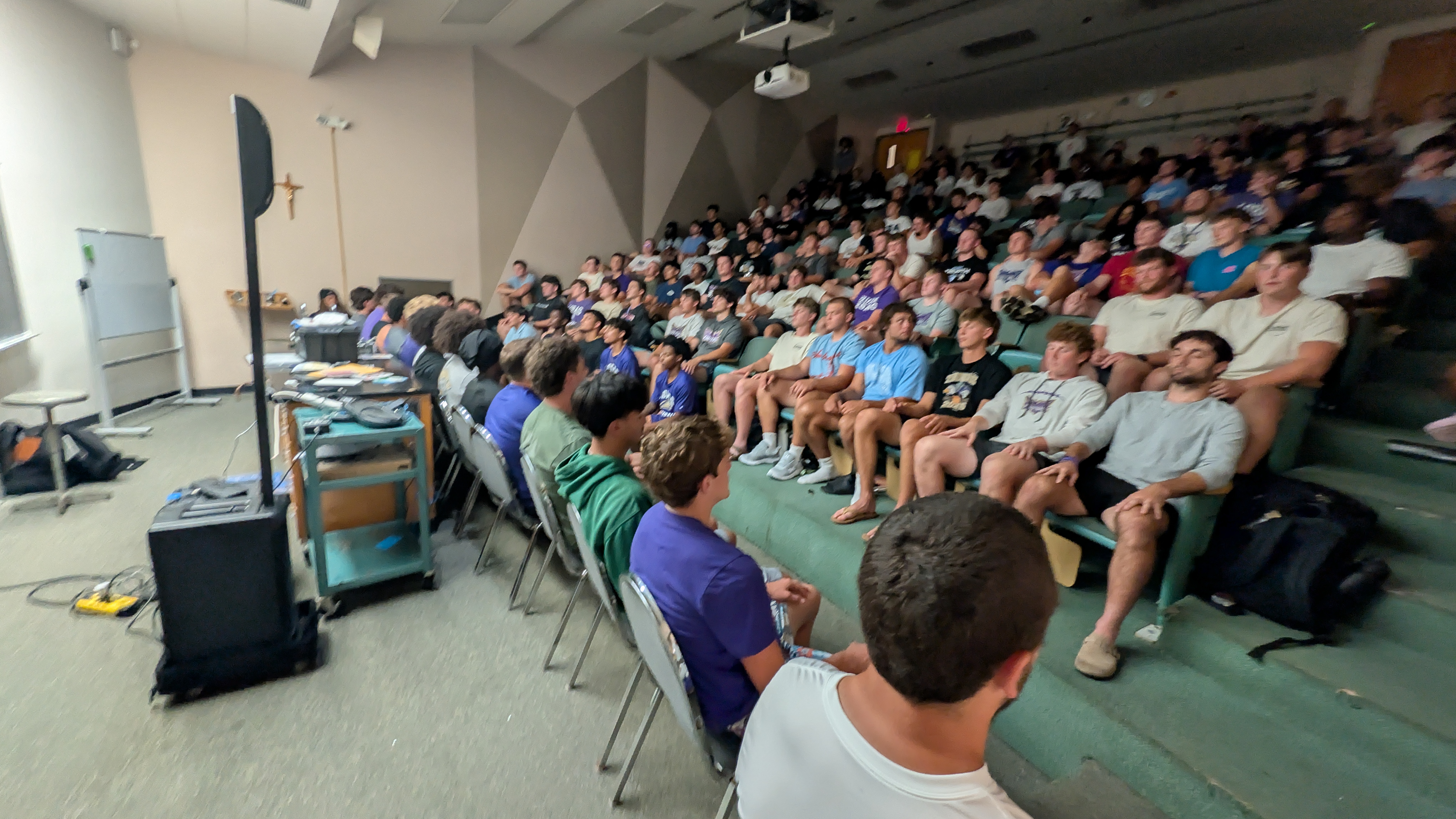 Forty Loras College football players on stage during a team bonding comedy hypnosis show