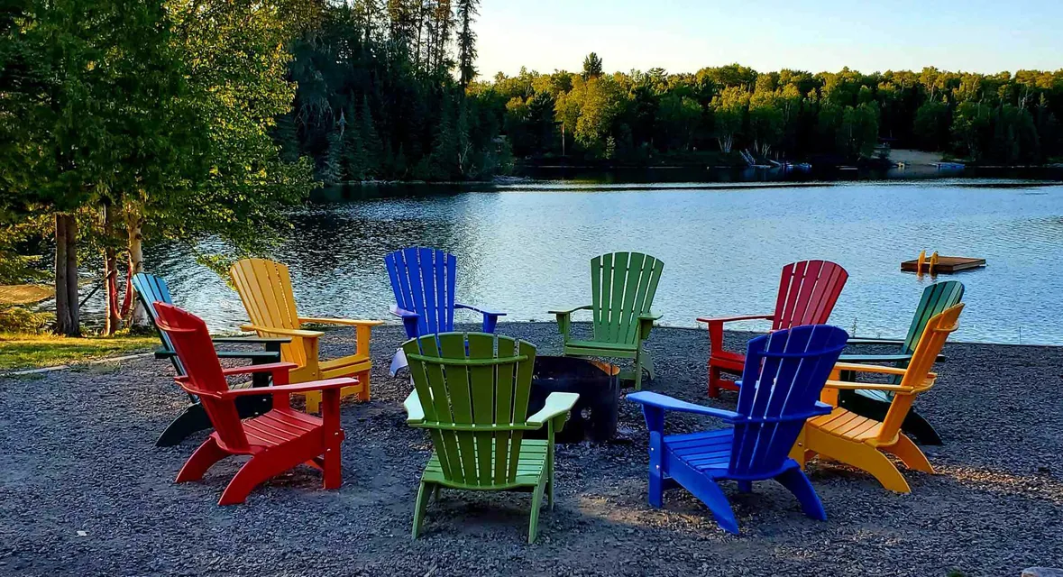 Muskoka chairs around fire on beach