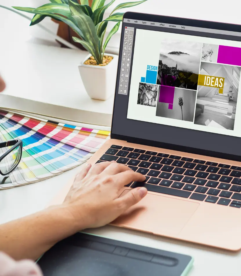 Graphic designer working on creative layout using color swatches and design software for print projects at Elite Printing Group in New Hampshire.