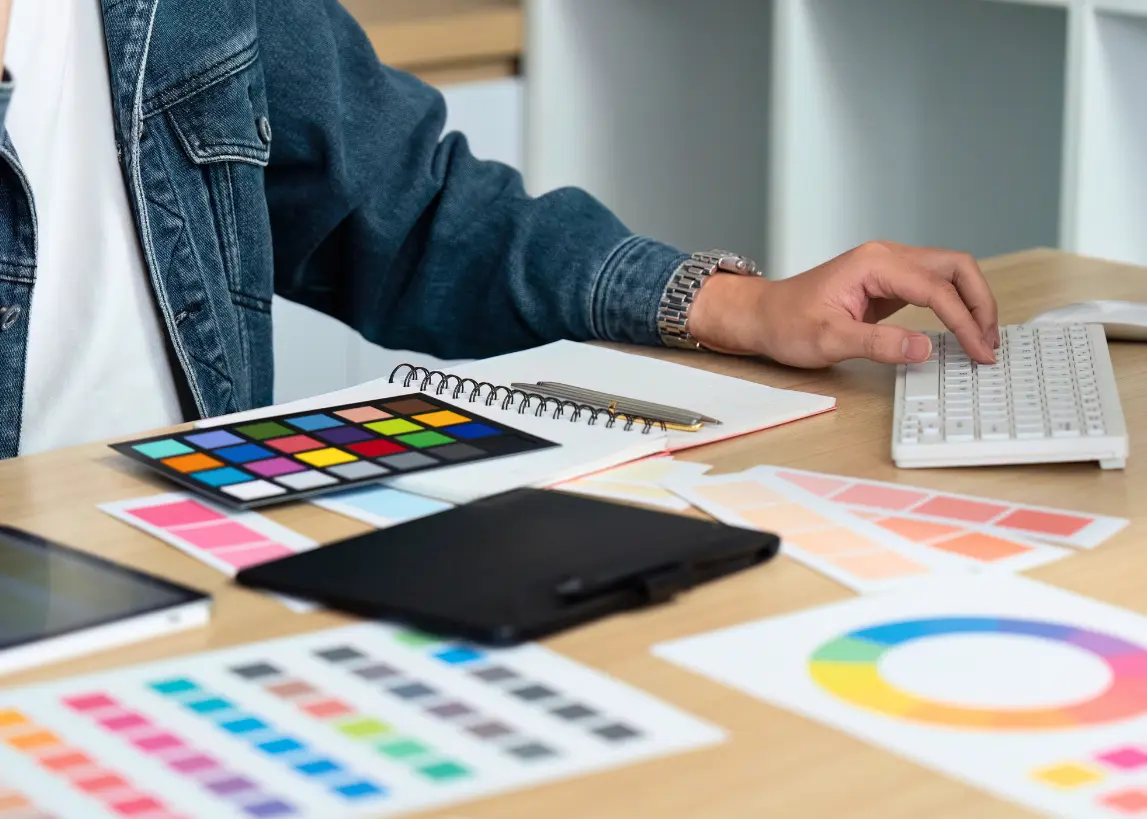 Graphic designer working on color palettes and print layout at Elite Printing Group, ensuring accurate color matching and professional design quality for print materials.