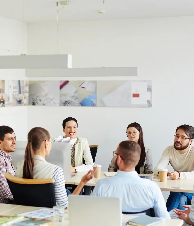 Marketing team meeting discussing creative design and business strategy in a modern office — professionals collaborating on branding and project planning.