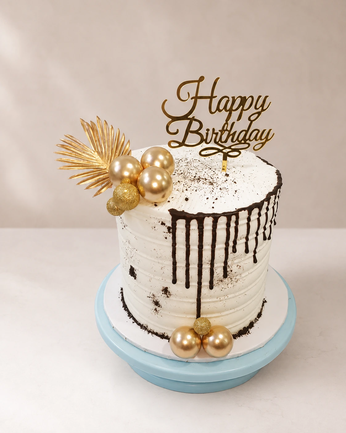 Chocolate drip birthday cake with gold ornaments and birthday topper
