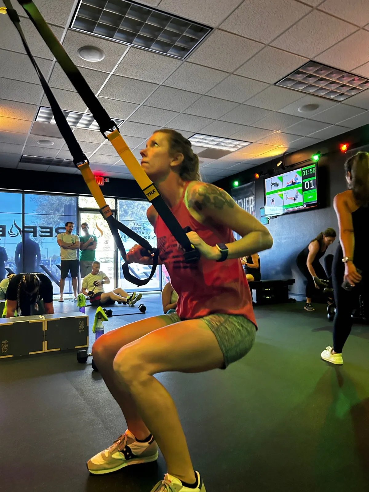 Member performing a TRX squat during class at REFUEL Bootcamp Crestview