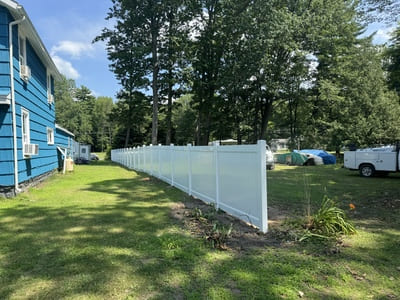 White vinyl privacy fence installed around a suburban yard