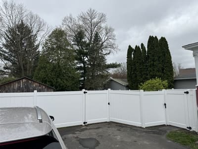 New white vinyl fence installed in a suburban backyard