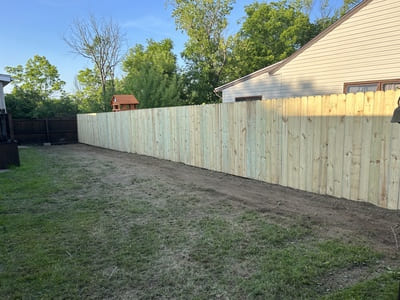 Freshly installed wooden privacy fence enclosing a suburban backyard