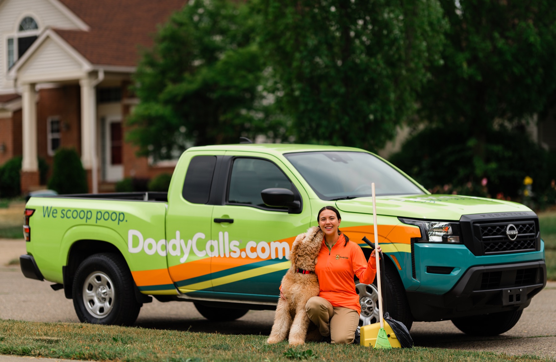 DoodyCalls technician with dog in front of a branded service truck
