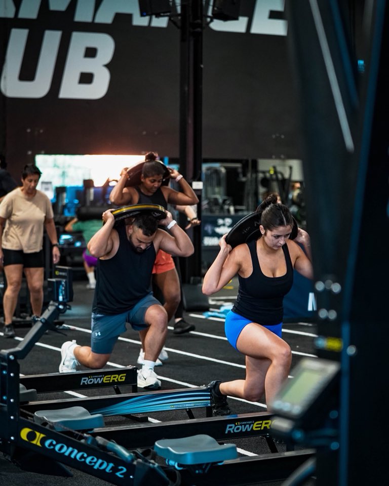 Two members lunging with sandbags on their shoulders