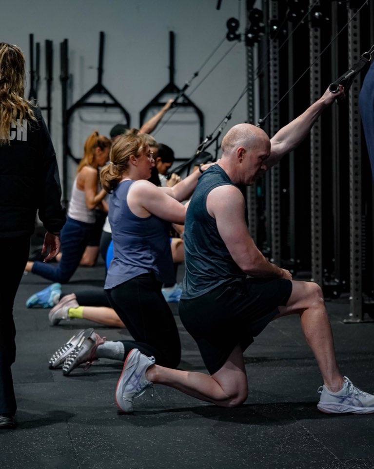 A class doing kneeling single-arm cable pulls