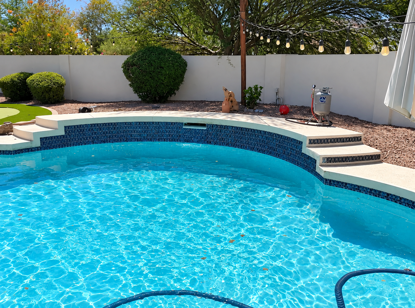 Sparkling residential pool with clear blue water maintained by Swim Clean Pool Services