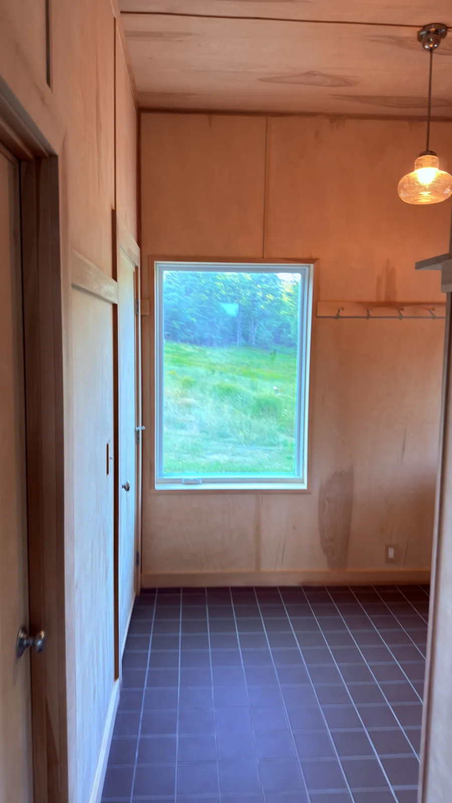 Custom mudroom with wood paneling and tile floor