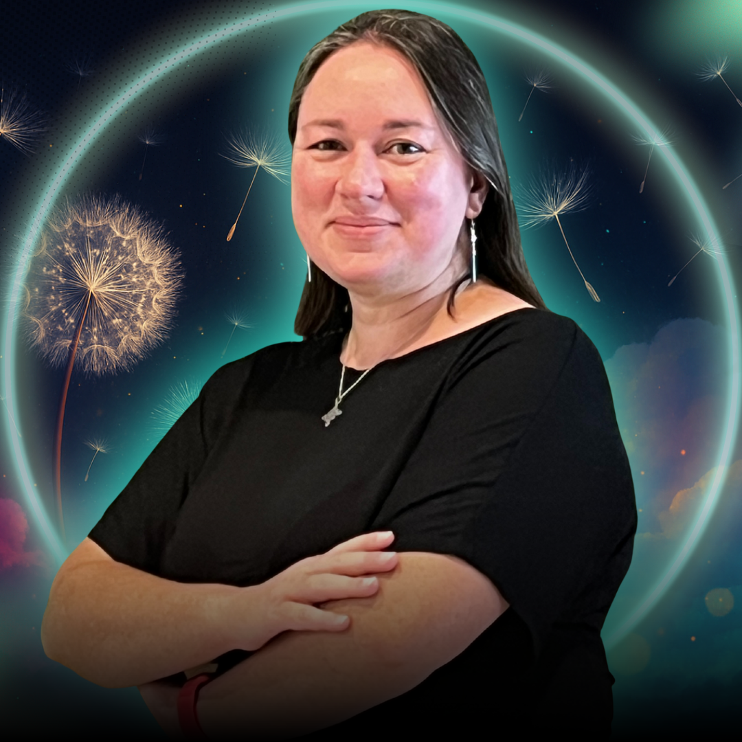 A charismatic Black woman in her 30s, wearing a bold pink blazer, standing confidently with arms crossed in a sunlit creative studio. The background features vision boards and plants, exuding energy and leadership.