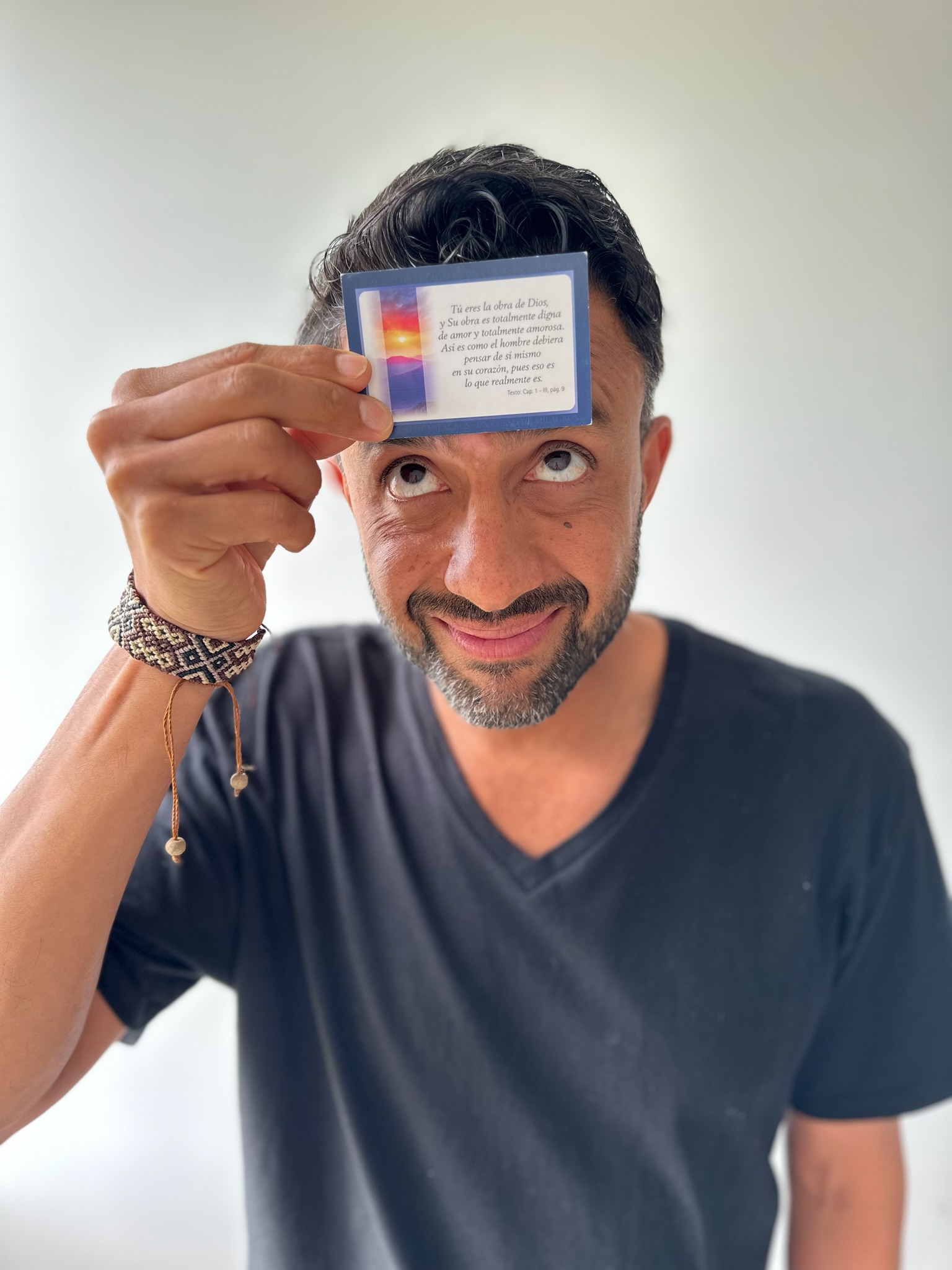 El Negro Monteiro con una carta de sabiduría de Un Curso de Milagros apoyada en la frente