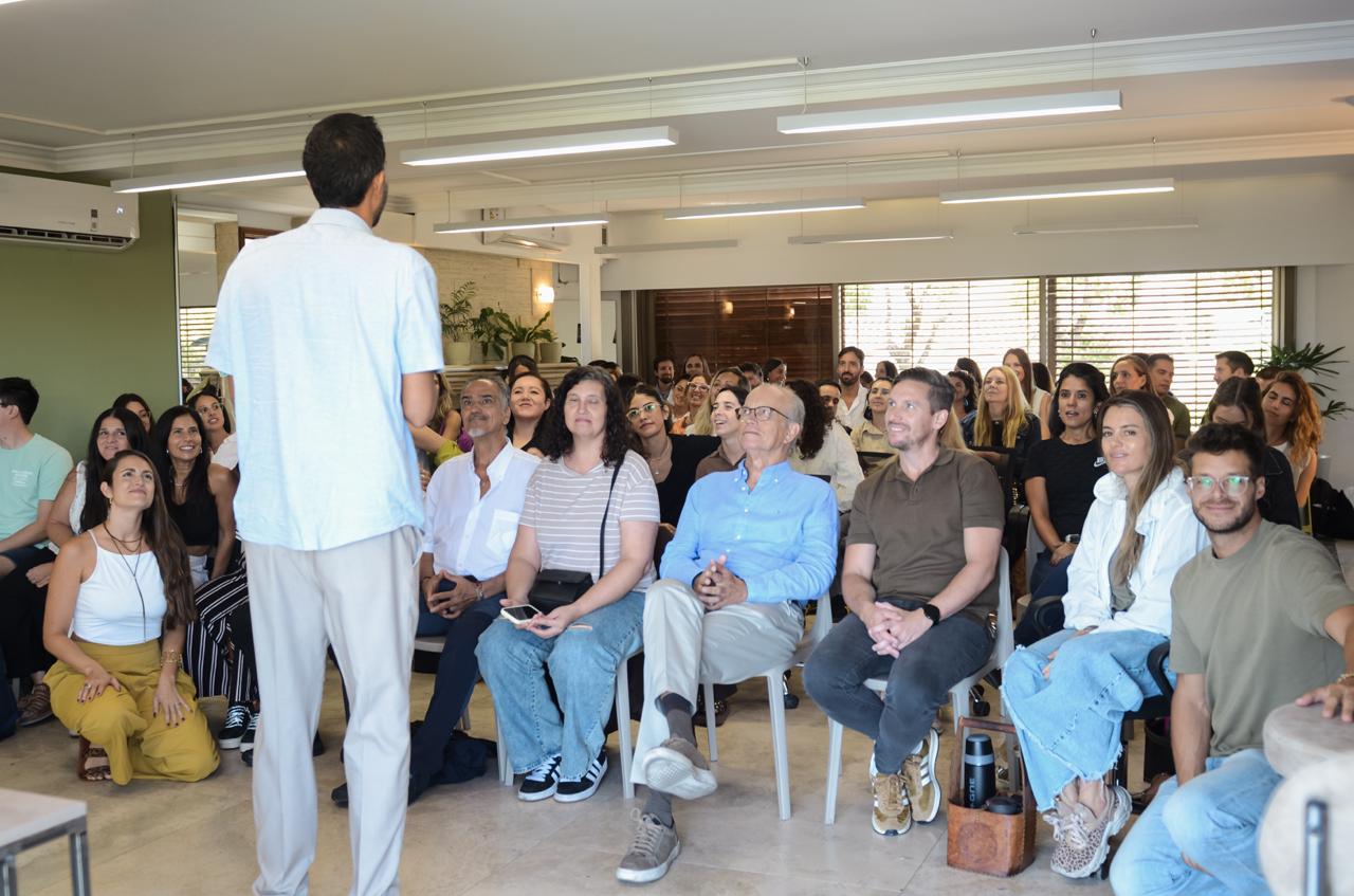 El Negro Monteiro de pie, de espaldas, dando una clase presencial a un grupo numeroso