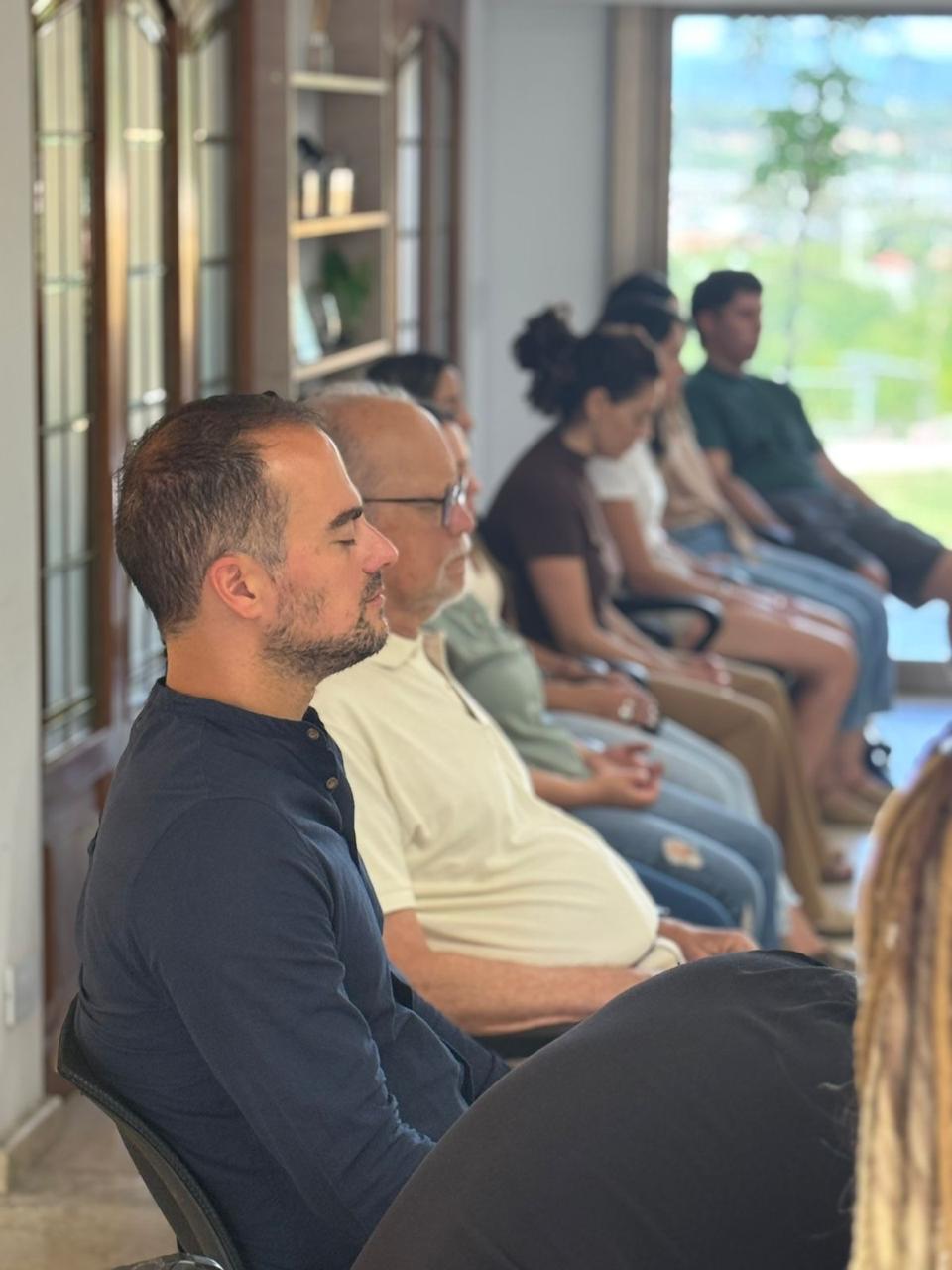 Un grupo de líderes con los ojos cerrados, durante una meditación