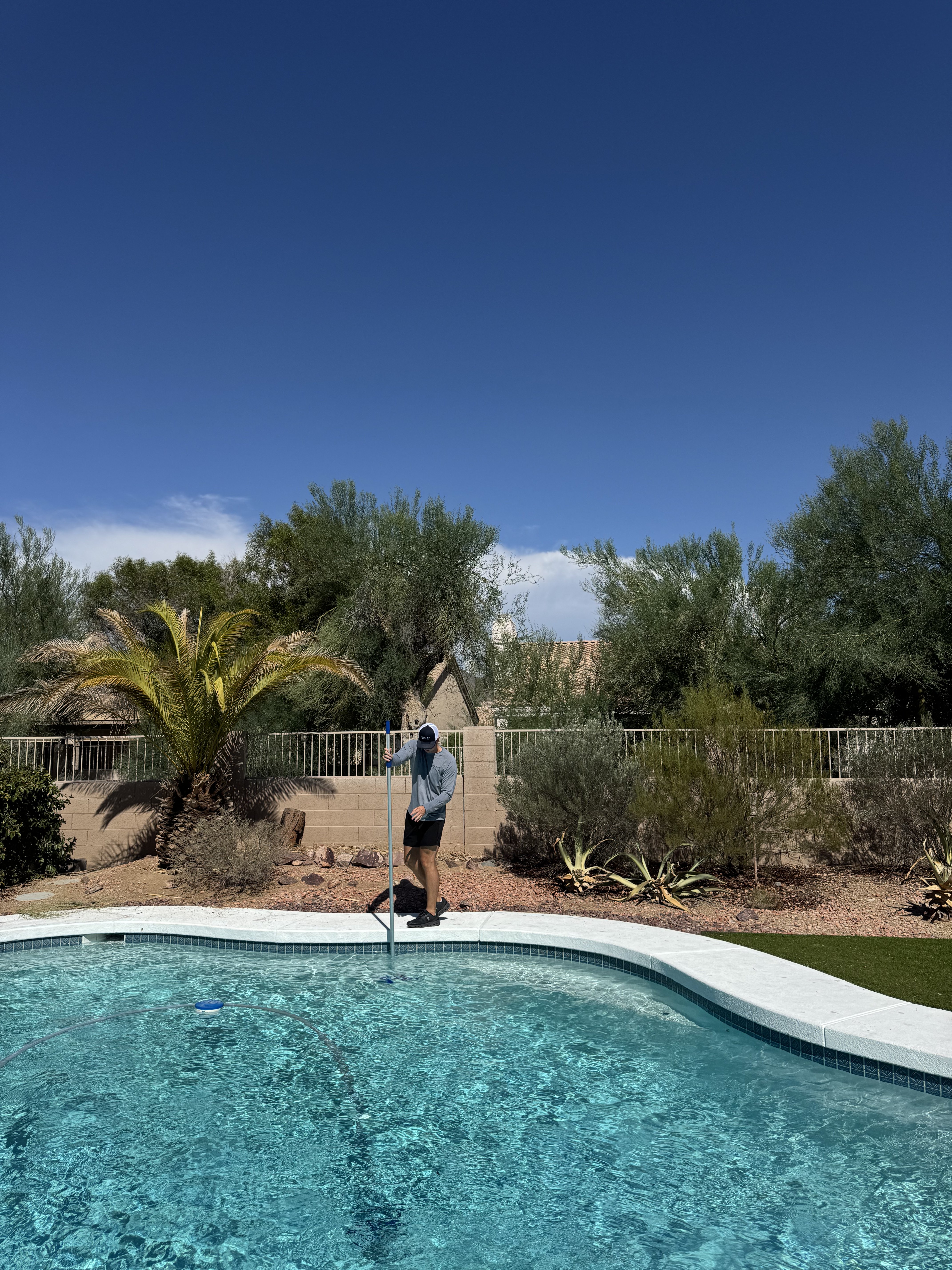 Colton skimming a residential pool during a weekly Drift Pool Co. visit