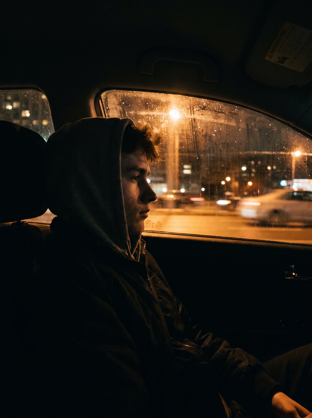 An athlete in the passenger seat on the drive home at night