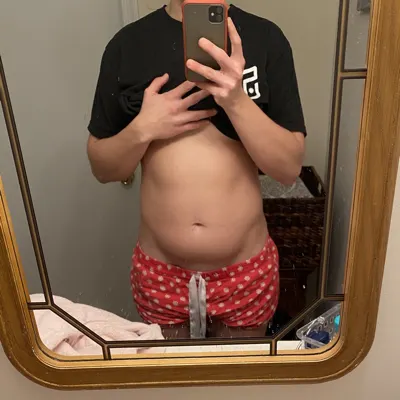 Jen in 2019, a mirror selfie with her shirt lifted to show a bloated stomach