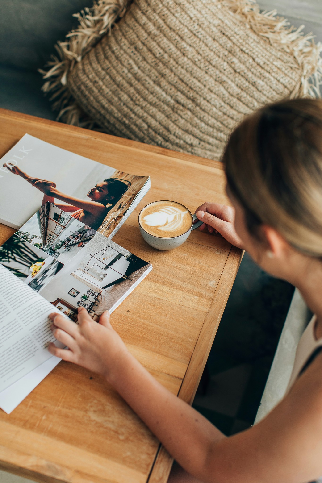 Woman reading magazine with hot coffee