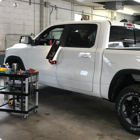Technician removing door ding from vehicle panel