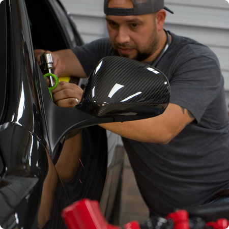 Technician using PDR tools on car door panel