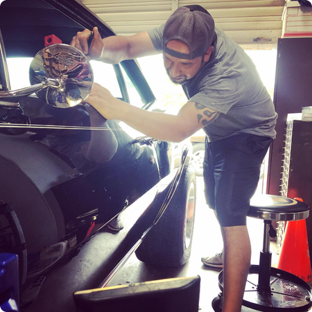 Technician removing door ding from vehicle panel