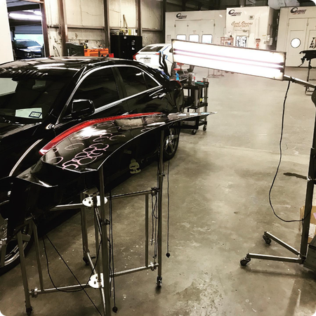 Technician repairing hail dents on car in Longview
