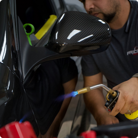 Technician using PDR tools on car door panel