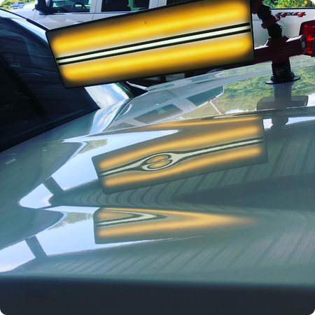 Close-up of hail dents on a car hood