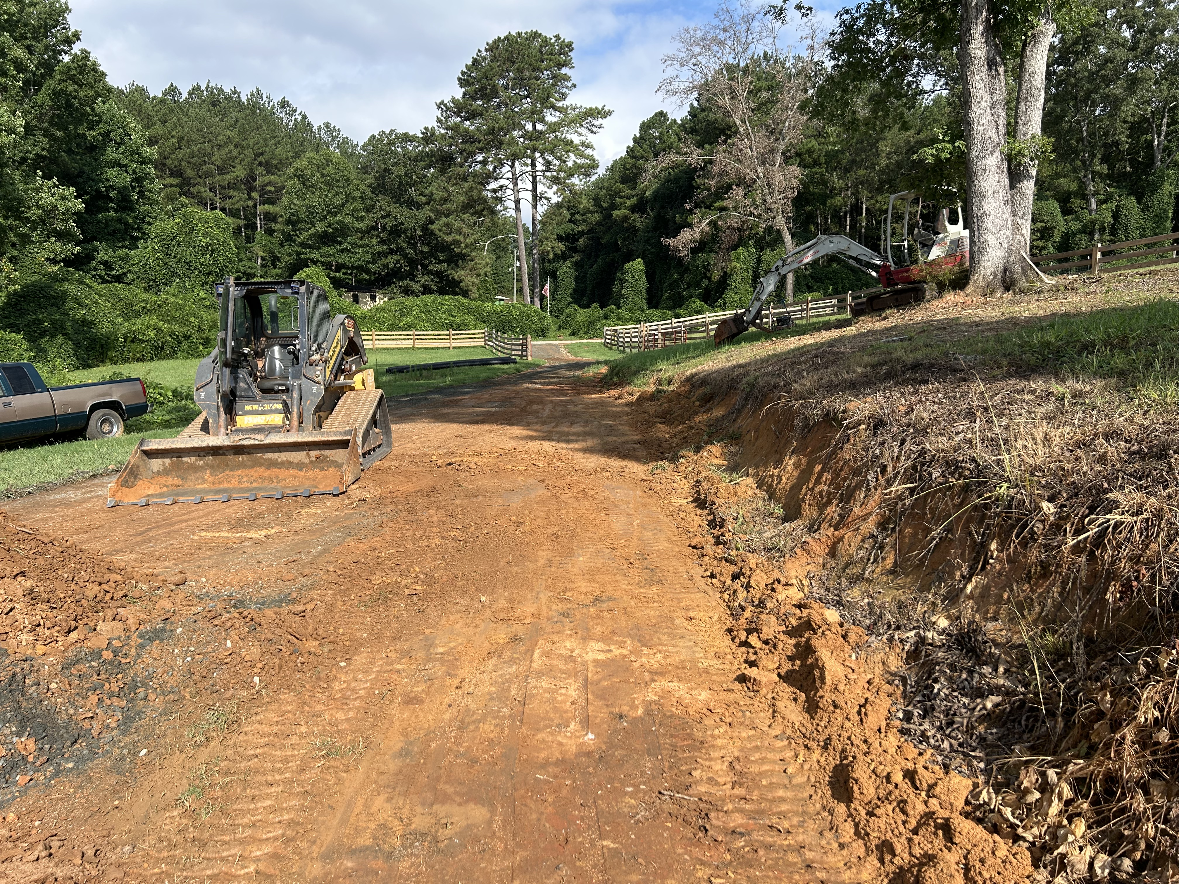 Tracked skid steer grading a farm driveway