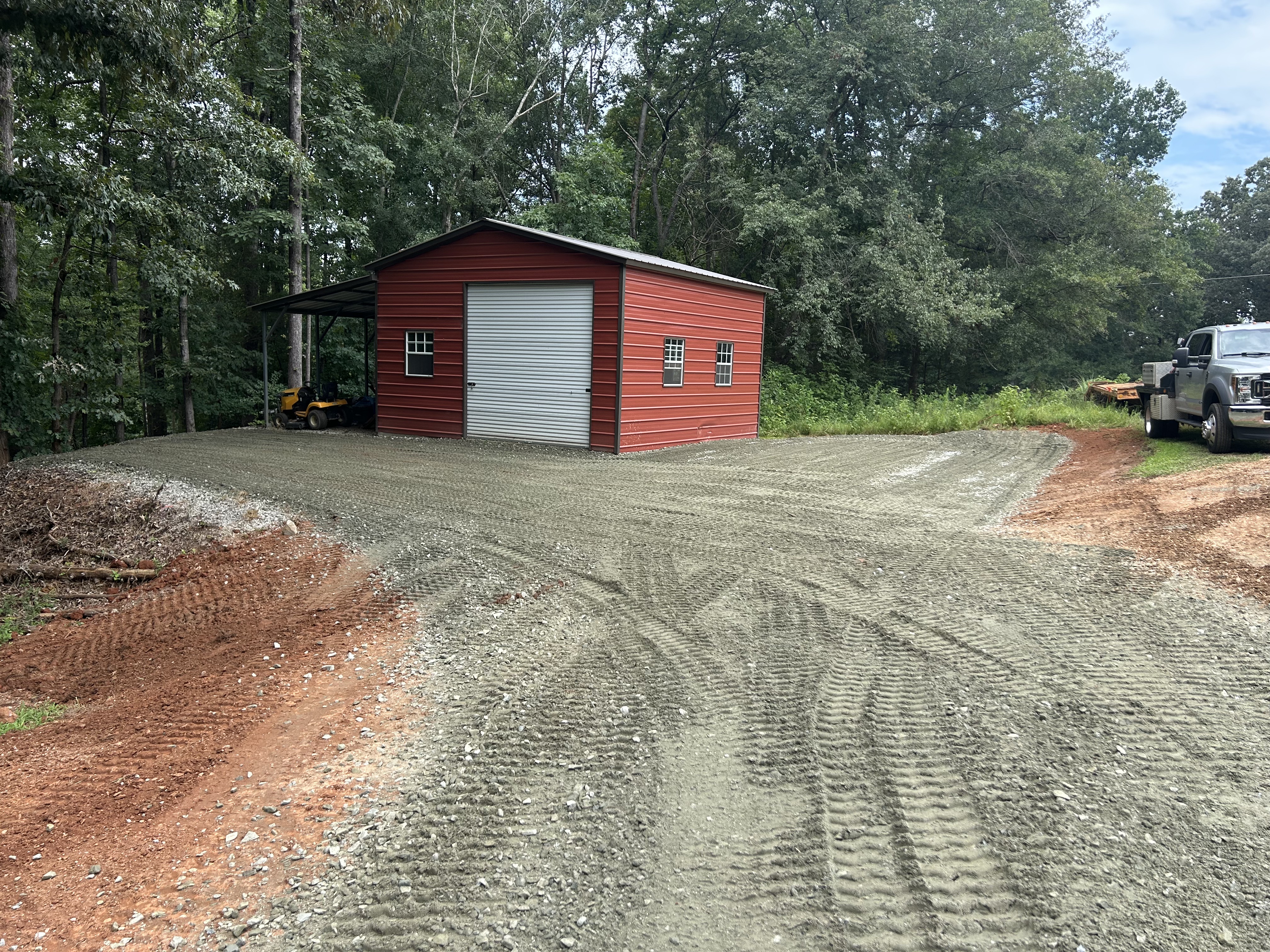 Metal garage with a new gravel driveway