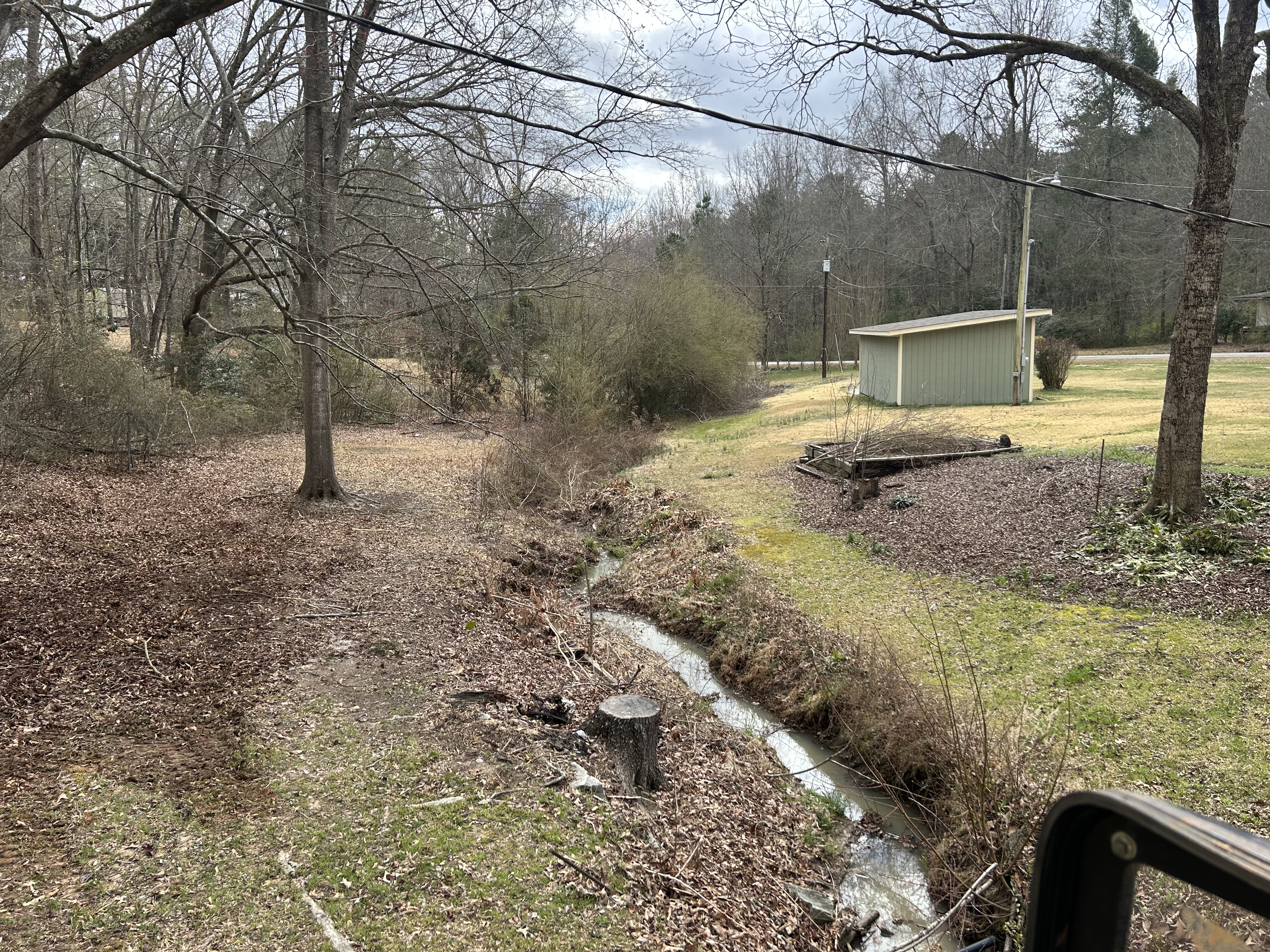 Eroded drainage ditch before work