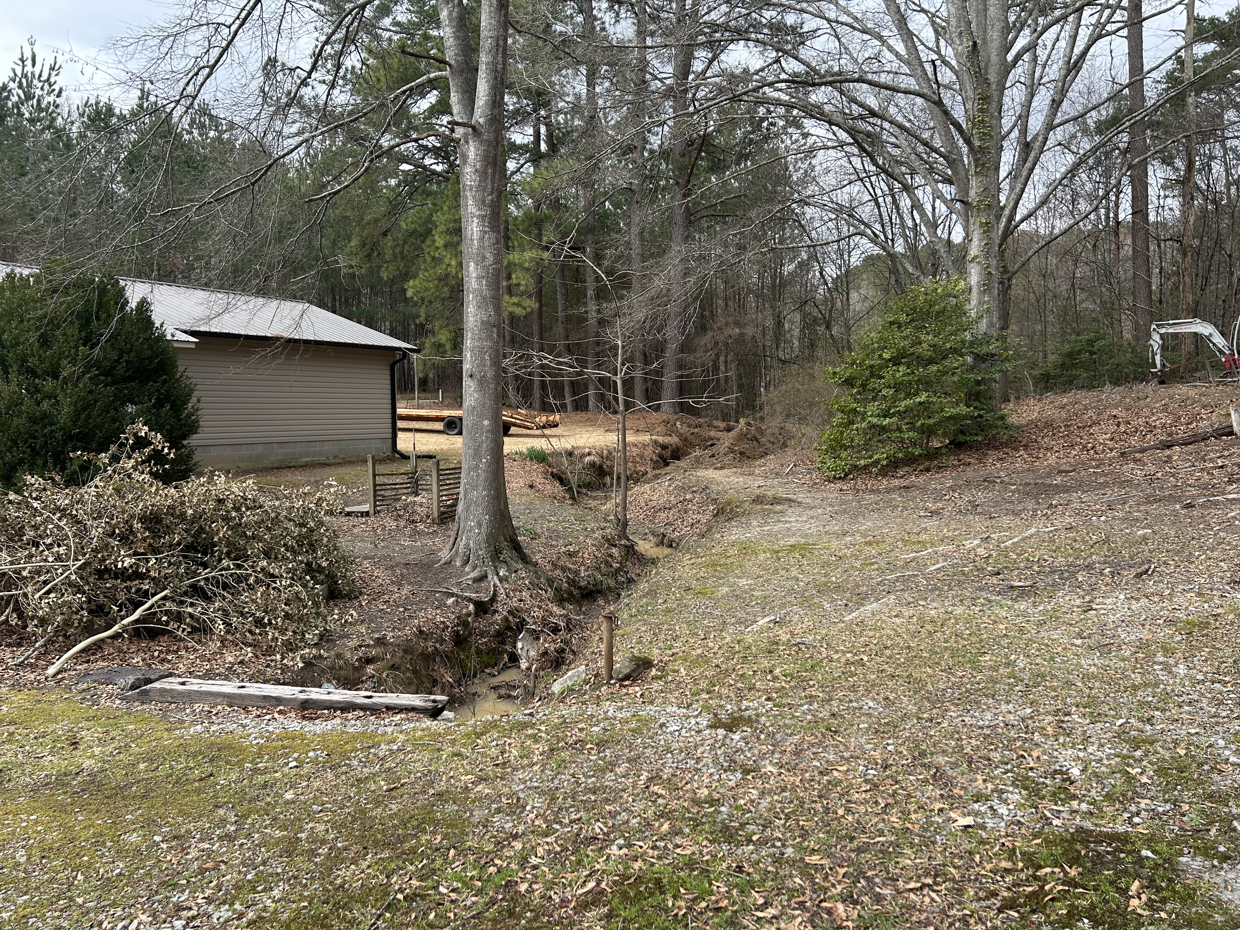 Eroded drainage ditch before work