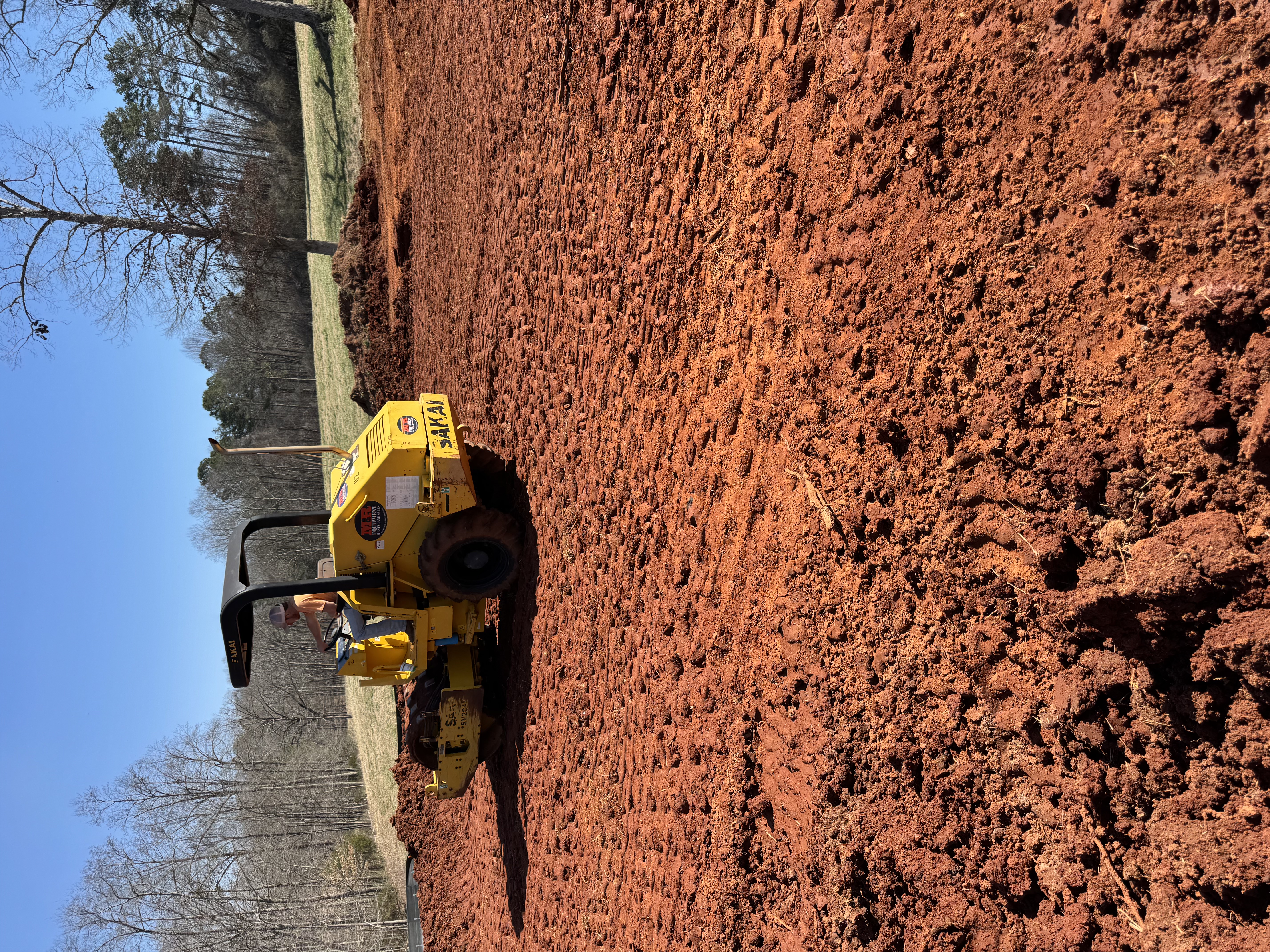 Roller compacting a building pad