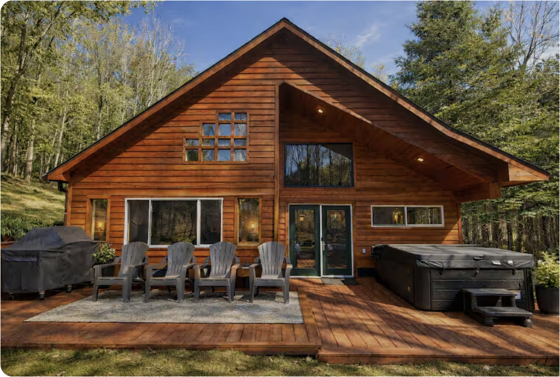 Cecily's luxury log cabin short-term rental in Boyne City, Michigan, with a deck, hot tub, and grill
