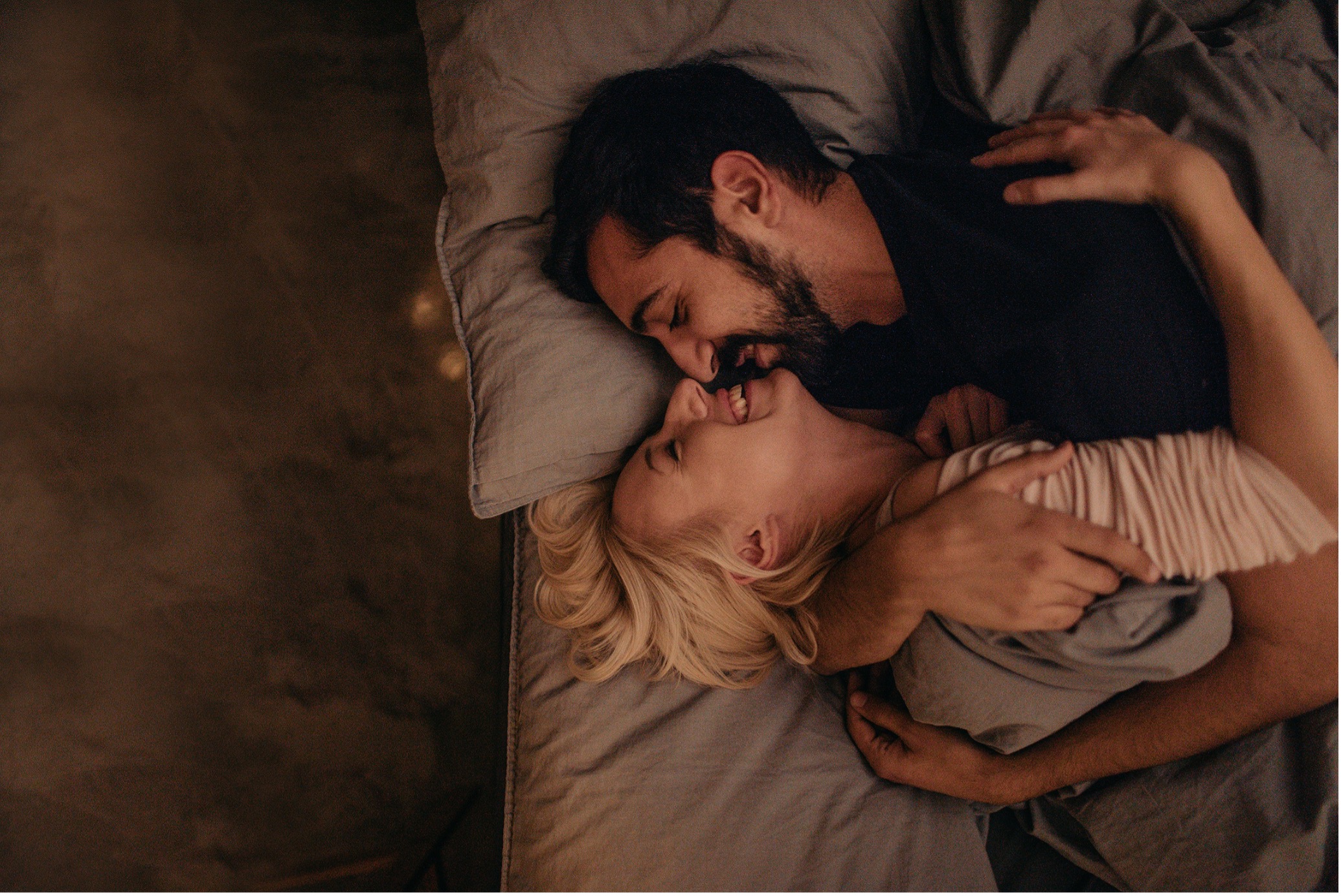 A couple laughing together in bed