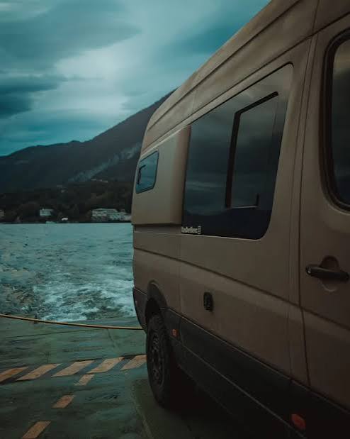 Close view of campervan side glazing beside a lake
